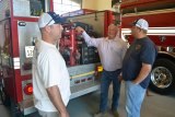 Lemoore firefighters are always on the job. Here, Sterling Stinger (left) and Stuart Lyons (right) confer with Fire Chief Bruce German.